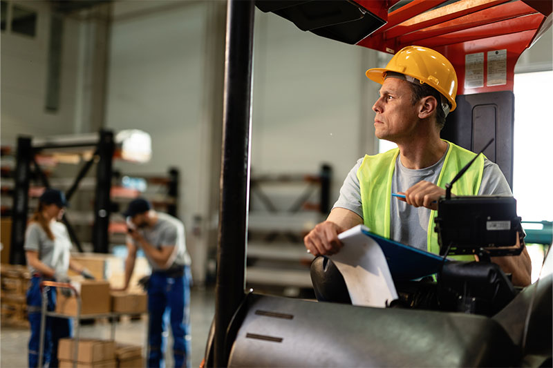 forklift collision warning Pensive forklift operator working in industrial warehouse.