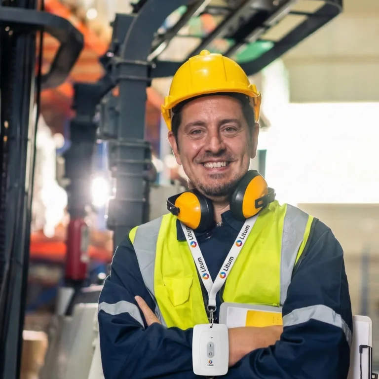 Industrial worker wearing a Litum connected worker tag and high-visibility vest