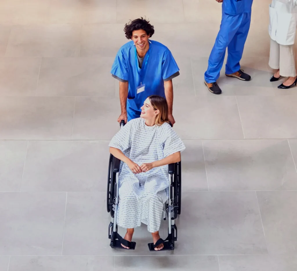 RTLS in Healthcare: Real-World Case Studies in Patient Safety, Staff Protection, and Asset Management 7 Nurse assisting an elderly patient in a wheelchair in a care home corridor