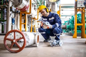 Asset tracking in hazardous areas — maintenance engineer handling pipe valve in petrochemical plant requiring real-time equipment tracking across classified zones