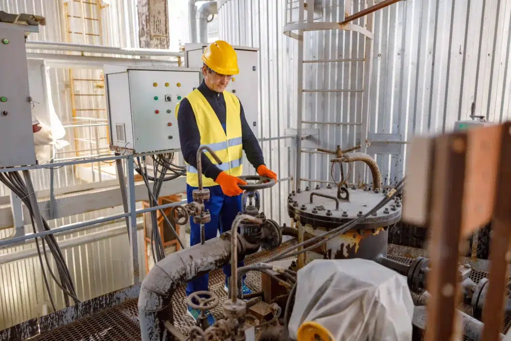 RTLS in Hazardous Areas: Five Cases Where the Litum ATEX Family Delivers Real Value 2 Engineer operating pipeline equipment at an oil and gas facility where RTLS oil and gas solutions monitor worker location and support emergency mustering