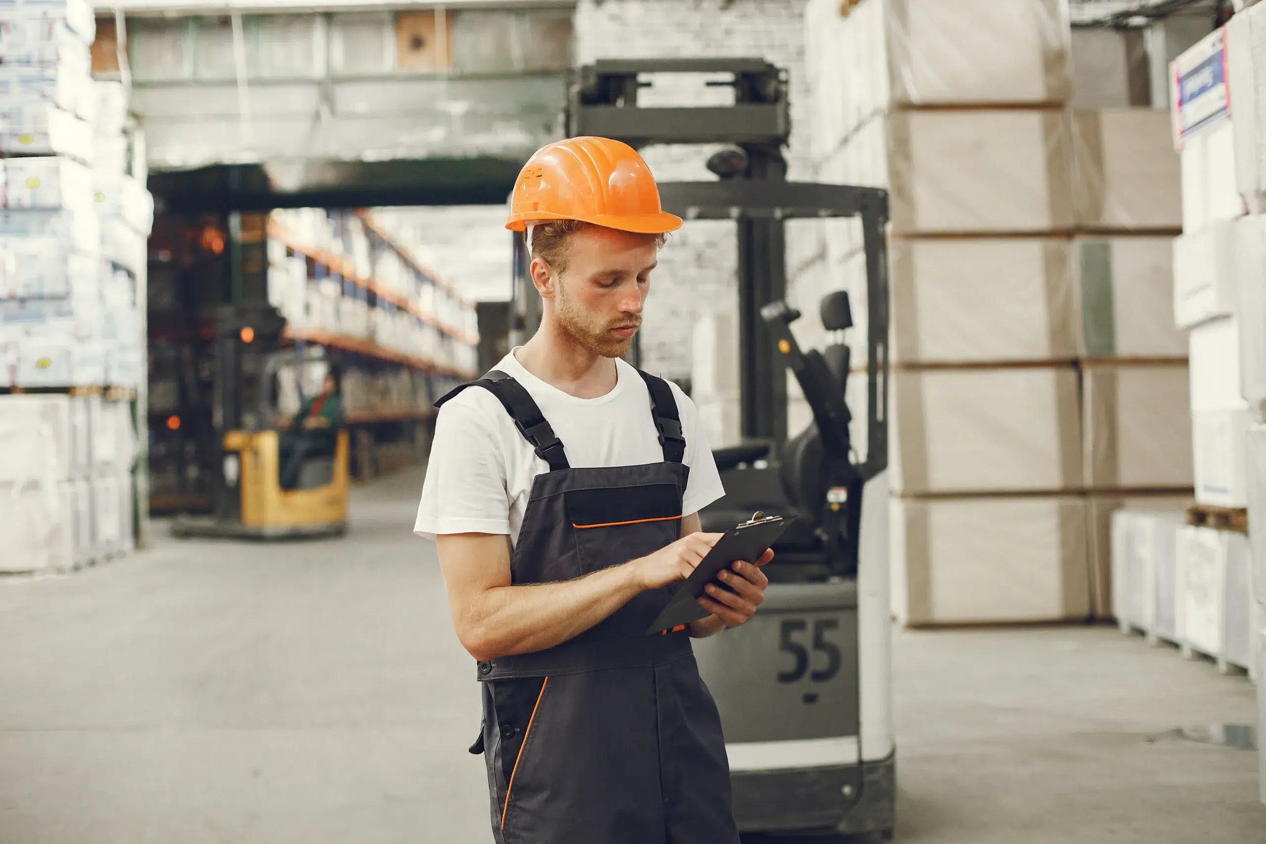 Home 79 Warehouse safety inspector reviewing forklift compliance checklist on clipboard