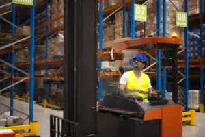 Forklift safety guide: operator relocating goods in warehouse