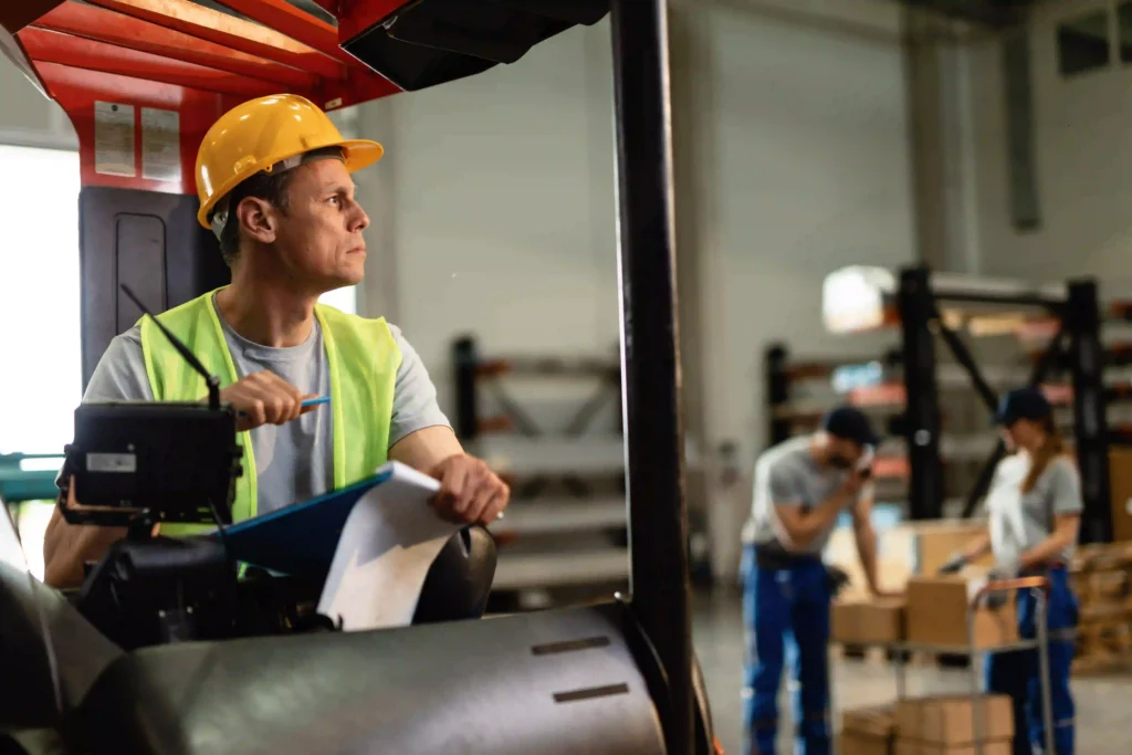 How to Choose an RTLS Vendor: The Industrial Buyer's Guide (2026) 1 Forklift driver relocating goods in a large warehouse distribution center where RTLS safety systems operate