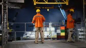 Worker in a hard hat conducting system inspections on an offshore drilling rig industrial platform