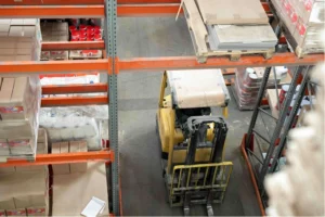 Forklift navigating narrow warehouse aisles where near misses often go unrecorded