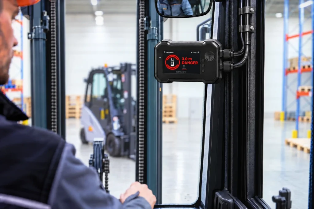 Your Forklift Already Knows What Is Happening. Now It Can Tell You. 2 PathAware IQ in-cab display showing a real-time 3.0m collision danger warning