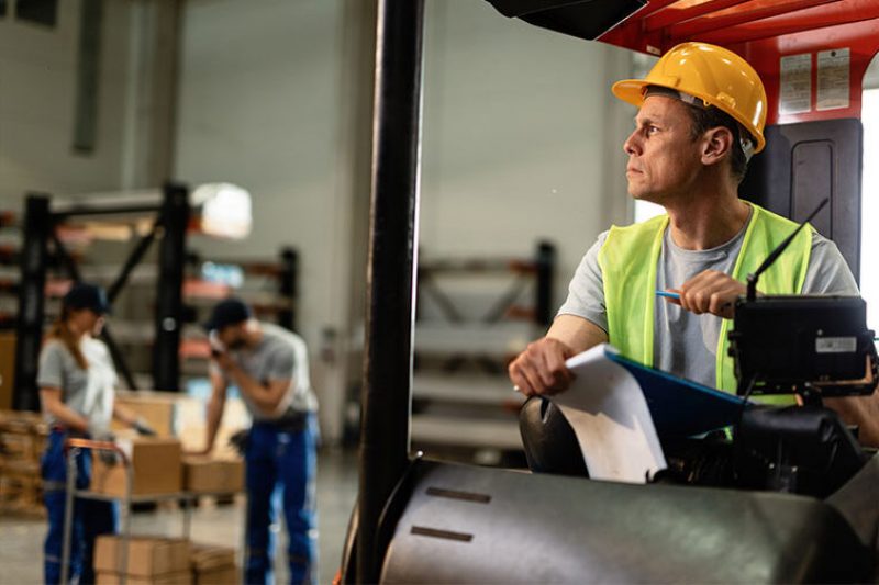 forklift collision warning Pensive forklift operator working in industrial warehouse